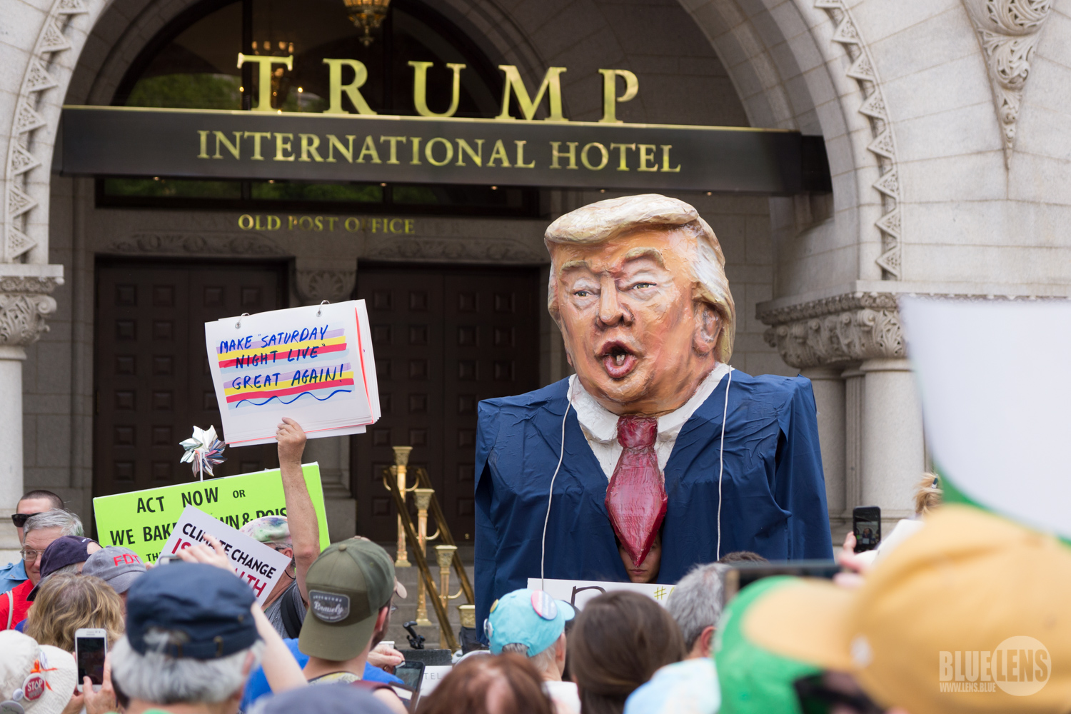 DC Climate March Against Trump 2017 Protestors outside of the Trump International Hotel, to the right of frame is a large caricature doll of Donald Trump.