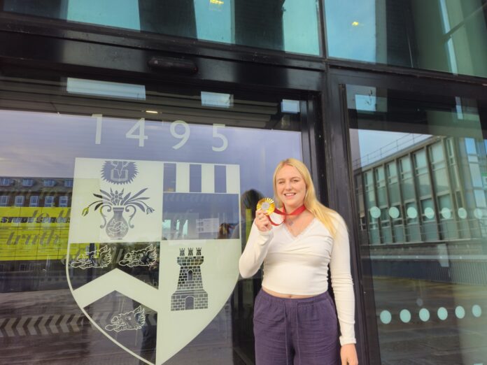 Faye Rogers poses with her gold medal outside the Sir Duncan Rice library