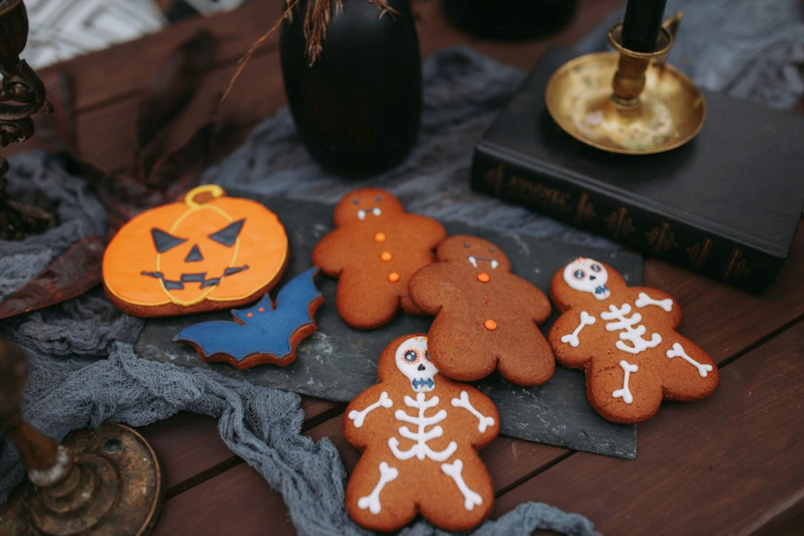 A photo of Halloween themed gingerbread. A photo of Halloween themed gingerbread. There are two gingerbread men as skeletons, two gingerbread men as vampires and a jack-o-lantern.