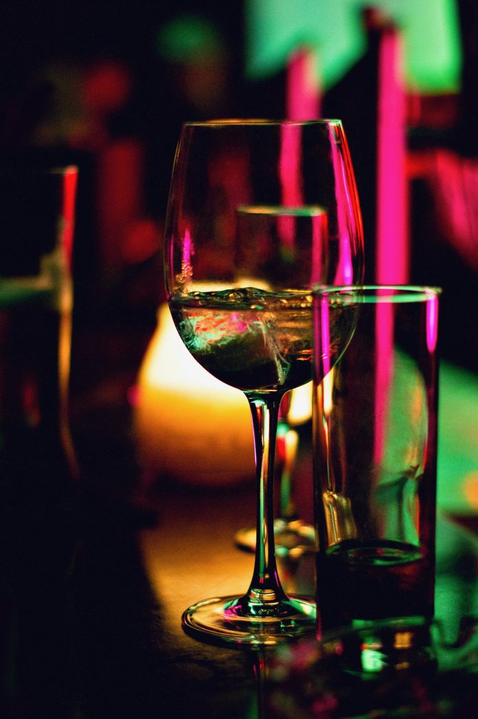 A wine glass under colourful lighting
