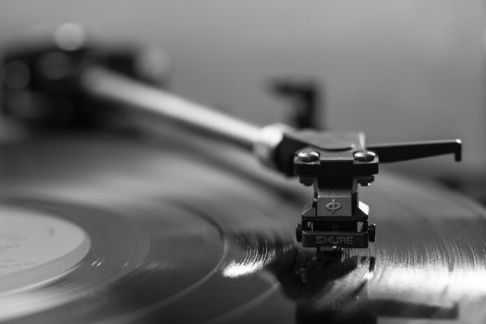 Black and white closeup of needle on vinyl record.