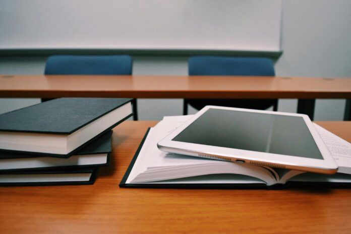 White tablet on top of open textbooks.