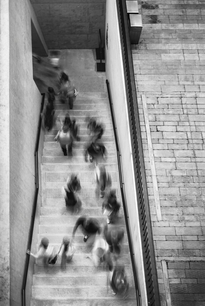 Black and white blurry shot of students in stairwell.