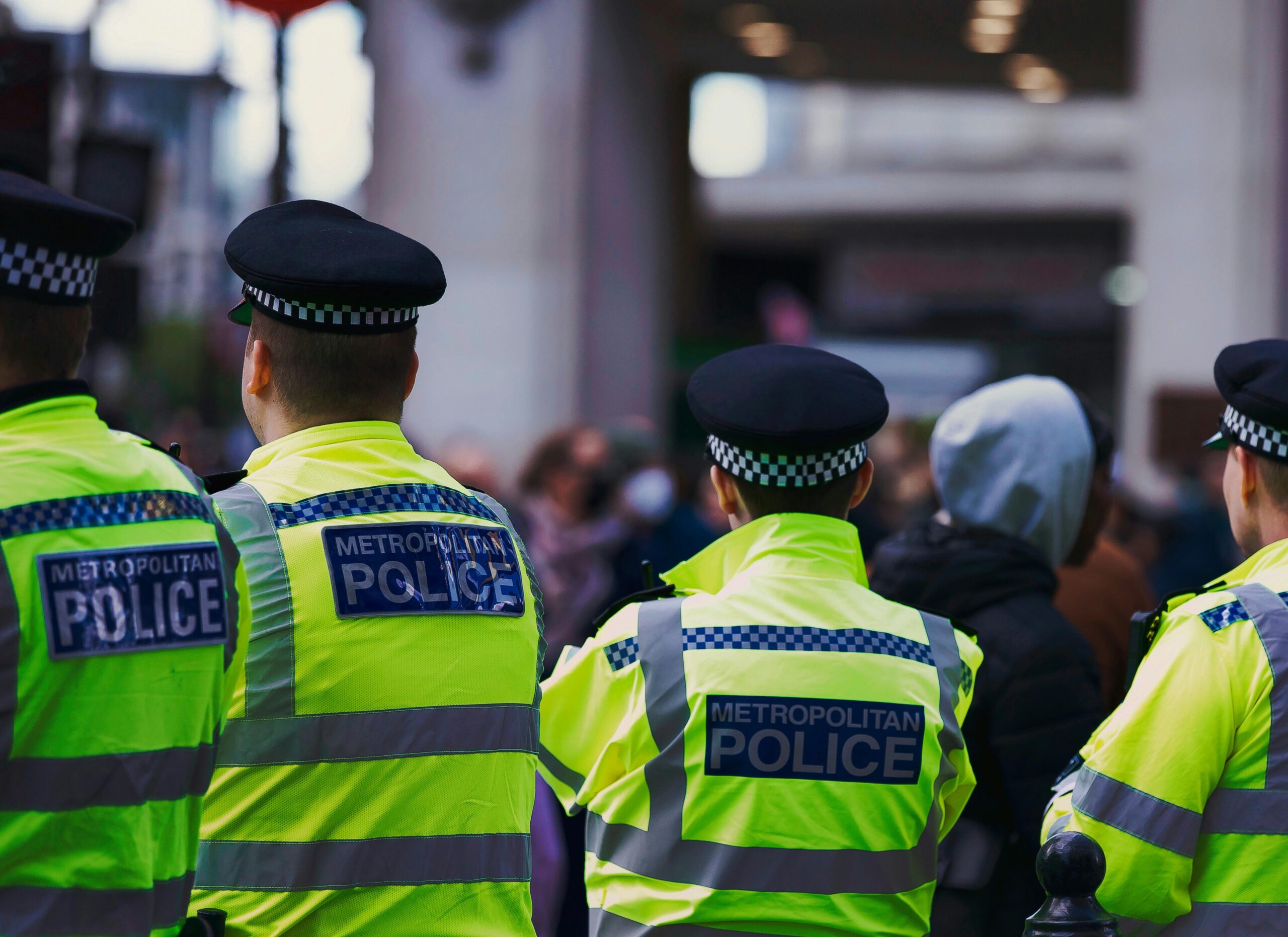 Skirting Equality Metropolitan police officers in yellow uniform jackets from behind