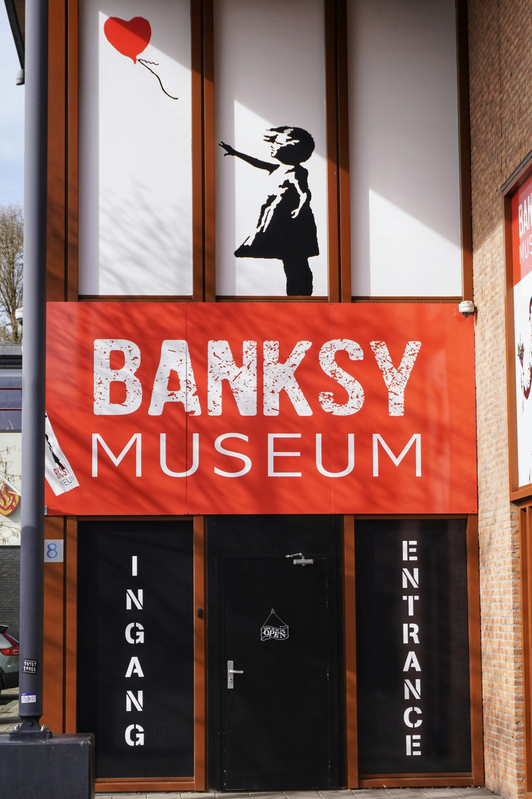 Your Crime is Your Trademark Banksy Museum entrance with 'girl with balloon' artwork above the door.