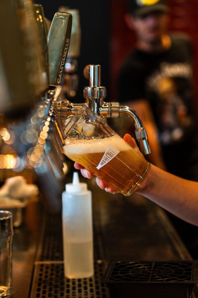 Bartender pulling pint of beer behind bar.
