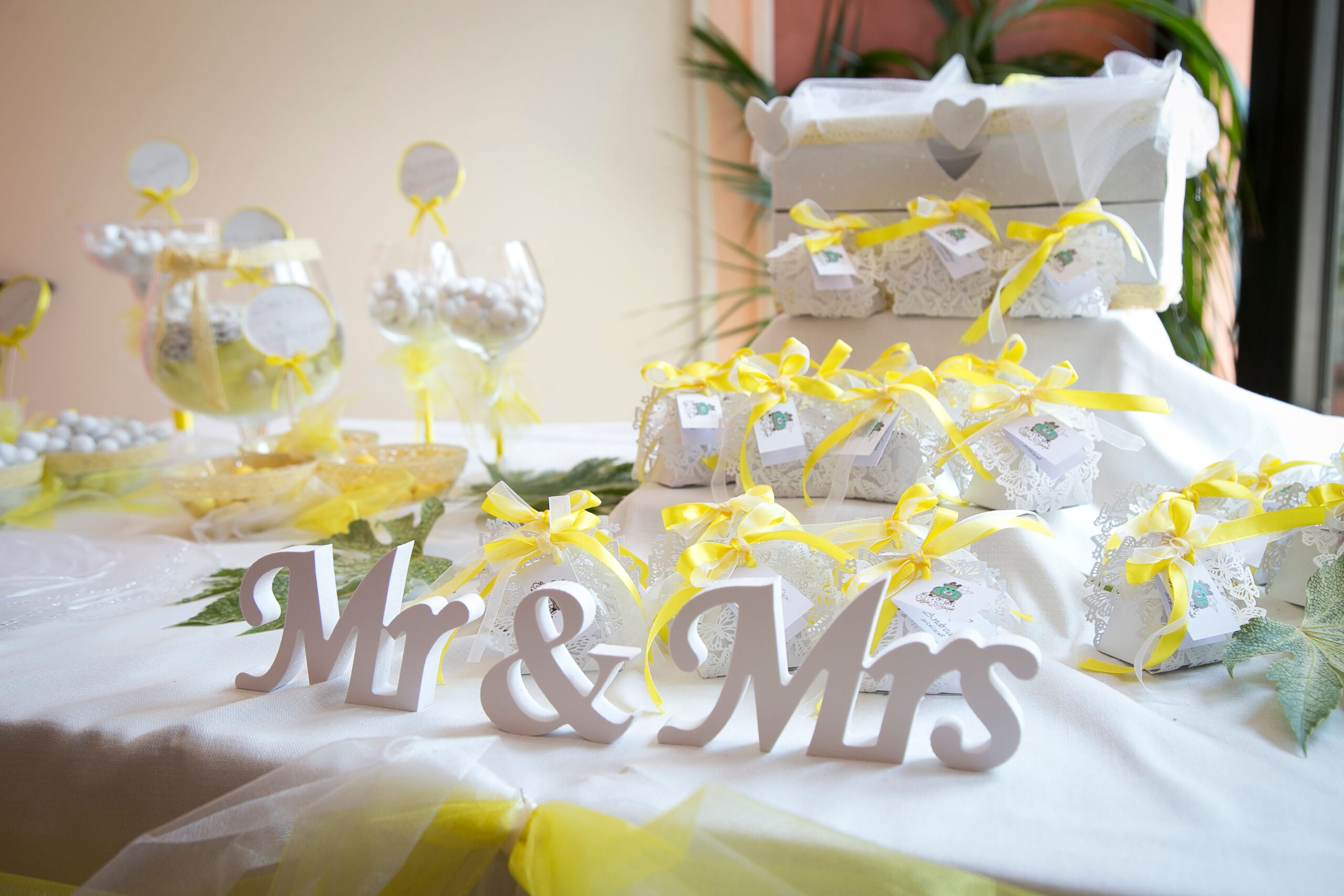 Gioele Fazzeri via Pexels Decorated wedding table in yellow and white, with gifts and Mr & Mrs sign in white.