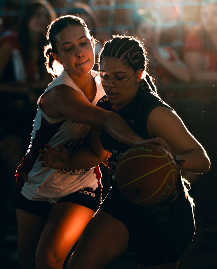 Dynamic moment from a competitive women's basketball match with intense player interaction.